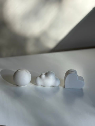 Minimalist sculptural card holders in sphere, cloud, and heart shapes, styled on a white surface.