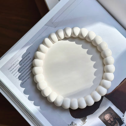 Halo handmade tray with scalloped shadow on open book in natural light