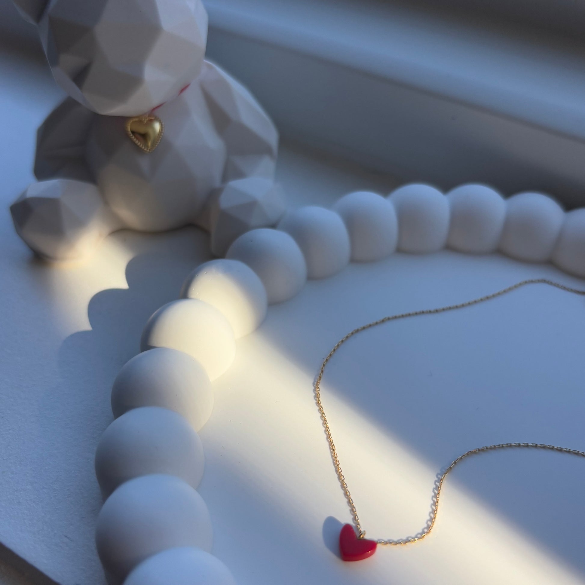 Halo handmade tray styled with red heart necklace and geometric bear figure in soft light